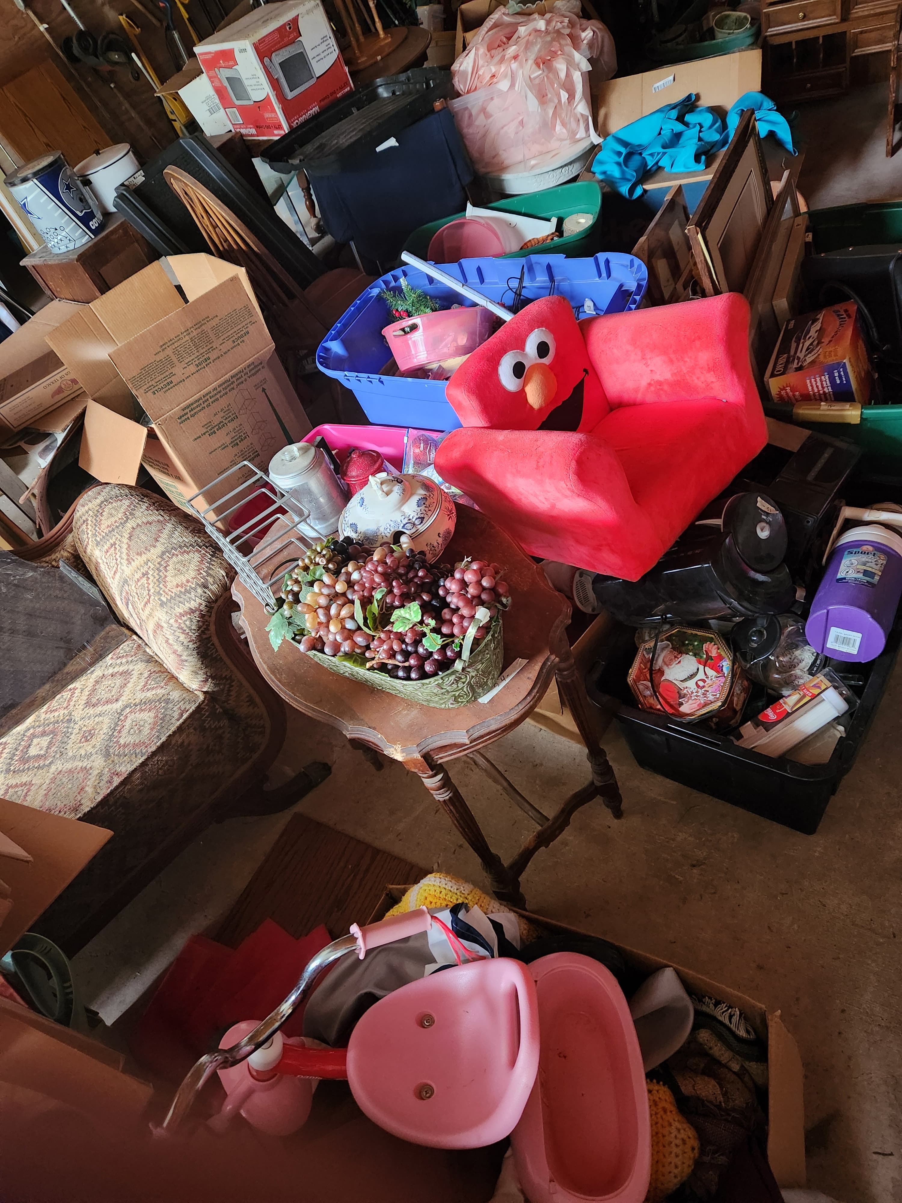 kids elmo chair on a pile of stuff in the garage